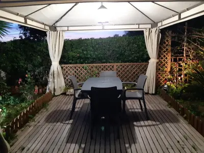a patio with a table and chairs under a canopy at CANAL SALINAS Solo Familias Serviplaya in Casas Las Basas