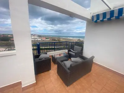 a balcony with wicker furniture and a view of the ocean at CANAL SALINAS Solo Familias Serviplaya in Casas Las Basas