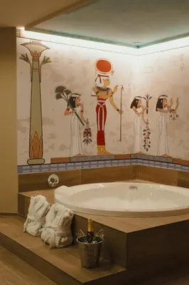 a bathroom with a tub and a wall with drawings at Valle del Nilo in Ventas de Poyo