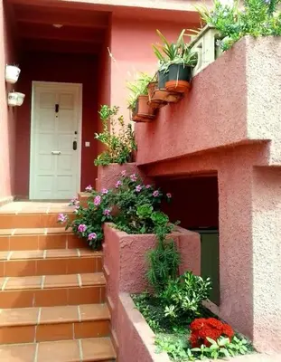 a pink building with potted plants on the side of it at Beachfront House, Valencia, Wifi, Paddle Surf Board, Incredible Views in Sueca