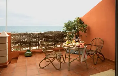 a balcony with a table and chairs and the ocean at Beachfront House, Valencia, Wifi, Paddle Surf Board, Incredible Views in Sueca