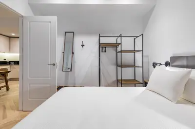 a bedroom with a white bed and a cross on the wall at Goerlich by Alma Suites in Valencia