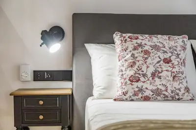a bedroom with a bed with a pillow and a nightstand at Goerlich by Alma Suites in Valencia