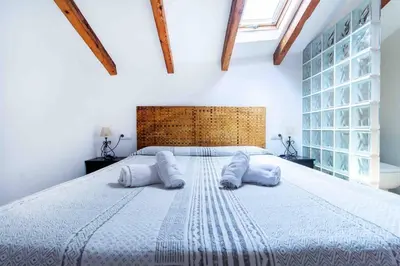 a bedroom with a large bed with two pillows at Acogedor Dúplex con terraza interior en la playa in Valencia