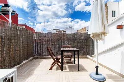 a table and chairs on a balcony with an umbrella at Estudio para parejas con terraza en la playa in Valencia