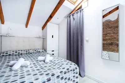 a bedroom with a bed with blue and white bedding at Estudio para parejas con terraza en la playa in Valencia