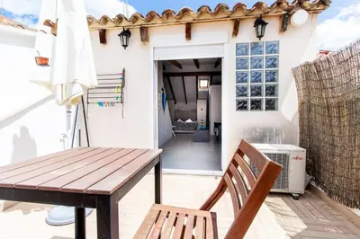 a patio with a wooden table and a wooden bench at Estudio para parejas con terraza en la playa in Valencia