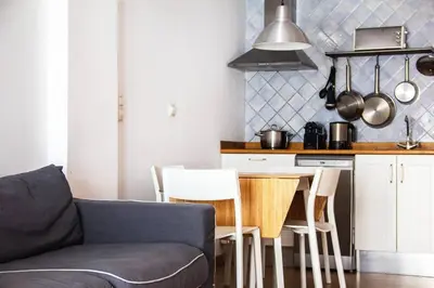 a kitchen with a couch and a table with chairs at Apartamento con terraza privada cerca de la playa in Valencia