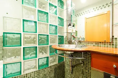 a bathroom with a sink and a tiled wall at Estudio para parejas con WIFI en la playa in Valencia