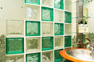 a bathroom with a glass block wall with a sink at Estudio para parejas con WIFI en la playa in Valencia