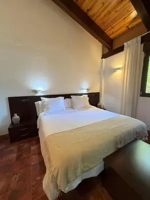 a bedroom with a large bed with white sheets at Pago de Tharsys in Requena