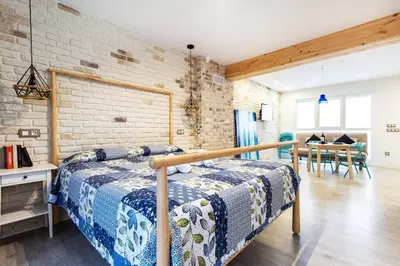 a bedroom with a bed and a brick wall at Chic y renovado loft en la playa in Valencia