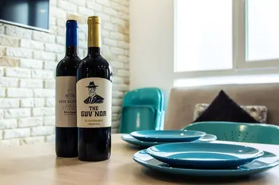 two bottles of wine sitting on a table with plates at Chic y renovado loft en la playa in Valencia