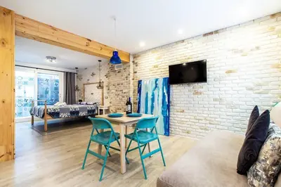 a living room with a table and chairs and a brick wall at Chic y renovado loft en la playa in Valencia