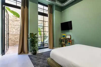 a living room with yellow walls and potted plants at AmazINN Collection Valencia Centro EVI in Valencia