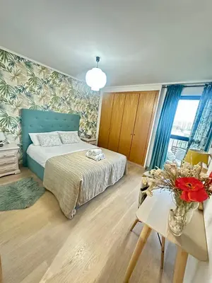 a bedroom with a bed and a table with a vase of flowers at Marin Beach Apartments Patacona in Valencia