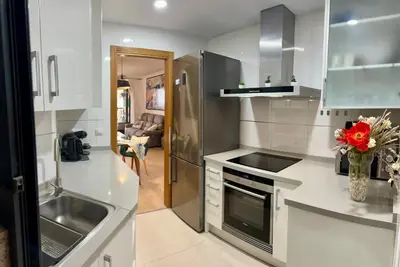 a kitchen with a table and a blue wall at Marin Beach Apartments Patacona in Valencia