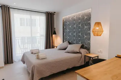 a bedroom with a bed and a large window at Hulot B&B Valencia in Valencia