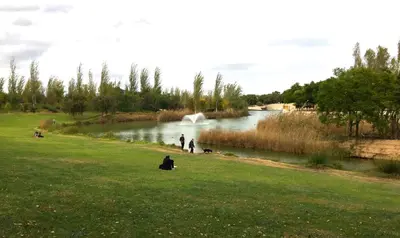 a group of people sitting in the grass near a river at Cosy flat with excellent location in Valencia! in Valencia