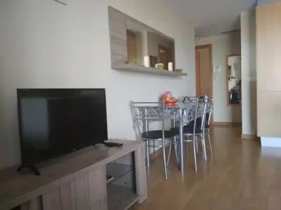 a living room with a television and a table with chairs at Apartamento Moncofar playa in Moncófar