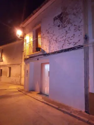 a white building with a door and a balcony at night at Casa Blanca in Algimia de Alfara