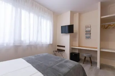 a bedroom with a bed and a flat screen tv at A Casa Martínez B&B in Valencia