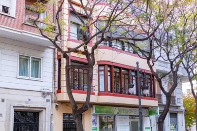 a pink and white building with a tree in front of it at A Casa Martínez B&B in Valencia