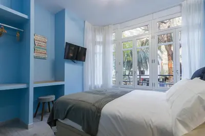 a blue bedroom with a bed and a window at A Casa Martínez B&B in Valencia