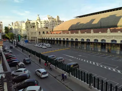 a city street with cars parked in front of a building at Main Central Station Apartment in Valencia