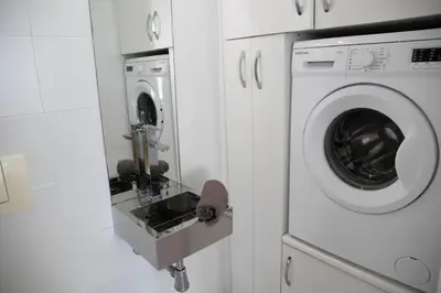 a washer and dryer in a white room at Apartamentos turísticos Cullera in Faro de Cullera