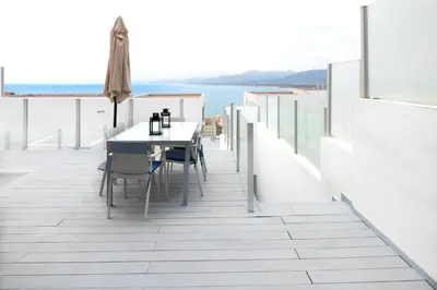 a balcony with a table and chairs and the ocean at Apartamentos turísticos Cullera in Faro de Cullera