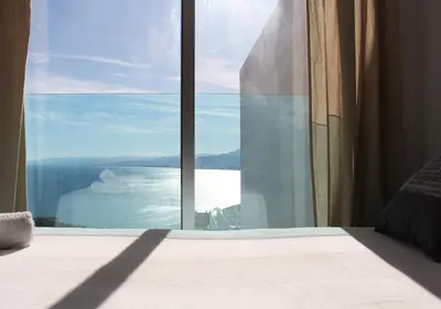 a bedroom with a large window with a view of the ocean at Apartamentos turísticos Cullera in Faro de Cullera