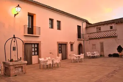 a large kitchen with a counter and a refrigerator at Masia de San Juan - castillo con piscina en plena Sierra Calderona in Segorbe