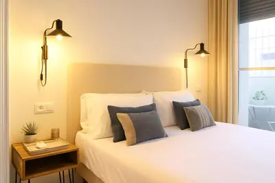 a bedroom with a white bed with pillows and a window at Encantador apartamento junto al Mediterraneo by Hometels in Puerto de Sagunto