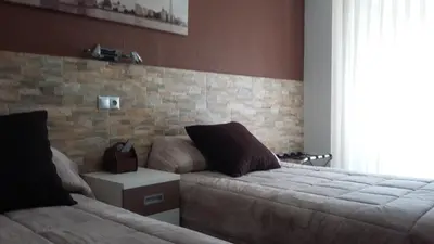 a bedroom with two beds and a couch at Hostal La Pilarica in Paterna