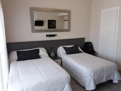 a hotel room with two beds and a mirror at Hostal La Pilarica in Paterna