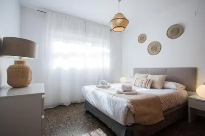 a white bedroom with a bed and a window at Apartamentos Carmen in Valencia