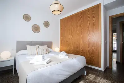 a bedroom with a large white bed with towels on it at Apartamentos Carmen in Valencia