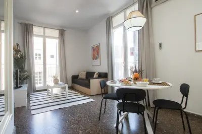 a living room with a table and chairs and a couch at Apartamentos Carmen in Valencia
