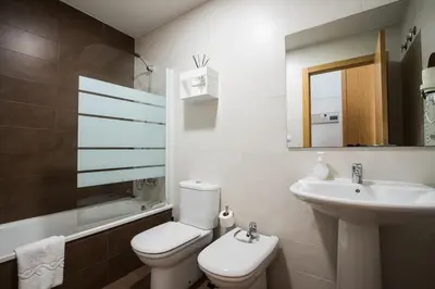 a bathroom with a white toilet and a sink at Apartamentos Carmen in Valencia
