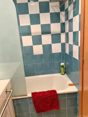 a bath tub in a bathroom with blue and white tiles at Urbanización Mar de Canet, 2 dormitorios con piscina comunitaria, garaje y wifi in Canet de Berenguer