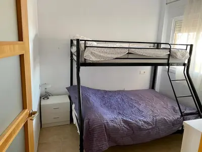 a bedroom with two bunk beds in a room at Urbanización Mar de Canet, 2 dormitorios con piscina comunitaria, garaje y wifi in Canet de Berenguer