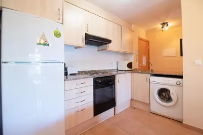 a kitchen with a refrigerator and a dishwasher at Global Vacacional, Apartamento en Marjal de Corinto con Piscina in Sagunto