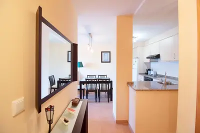 a kitchen and dining room with a large mirror at Global Vacacional, Apartamento en Marjal de Corinto con Piscina in Sagunto