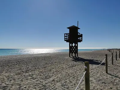 a lifeguard tower on a beach next to the ocean at Global Vacacional, Apartamento en Marjal de Corinto con Piscina in Sagunto