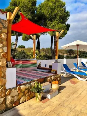 a patio with a table and chairs and an umbrella at LEMON TREE VILLA in Monserrat
