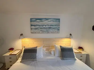 a bedroom with a white bed with two night stands at LEMON TREE VILLA in Monserrat