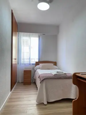 a small bedroom with a bed and a window at Lovely 3-Bedroom Apartment 15 Minutes from Beach in Valencia