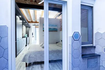 a bedroom with a bed in a room with windows at Chic estudio privado al lado de la playa in Valencia
