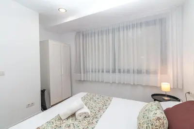 a white bedroom with a bed and a window at BET Apartments - Reig in Valencia